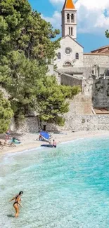 Scenic beach with turquoise waters and historic church view.