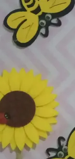 Colorful felt sunflower and bees on a pink zigzag background.