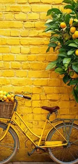 Yellow bicycle with oranges by a vibrant wall.