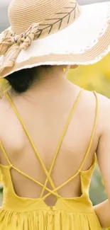 Back view of a woman in a yellow dress and hat amidst a sunflower field.