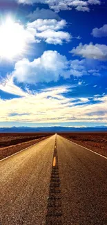 Vibrant desert road under a sunny blue sky and fluffy clouds.