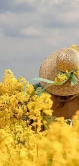 Woman in straw hat in a sunny yellow flower field.