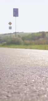 Sunlit countryside road with clear sky.