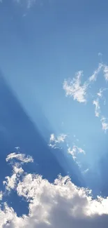 Blue sky with sun rays shining through white clouds mobile wallpaper.