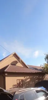 Sunny suburban house under a bright blue sky, surrounded by nature.