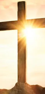 Golden sunrise behind a silhouetted wooden cross on a hilltop.