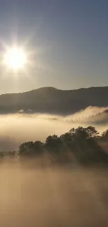 Beautiful sunrise over misty mountains with sunlight streaming through clouds.