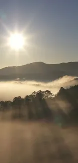 Sunrise over misty mountains with sun rays and clouds.