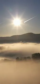 Misty mountains under a rising sun with a clear sky.