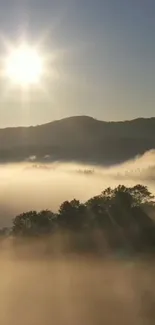 Sunrise over misty mountains with sun rays.