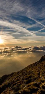 Sunrise over mountains and clouds with a serene blue sky.