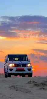 SUV driving across desert dunes at sunset.