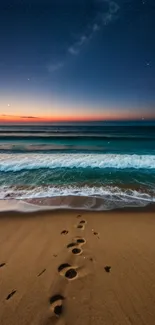 Footprints leading to the ocean at sunset with a starry sky backdrop.