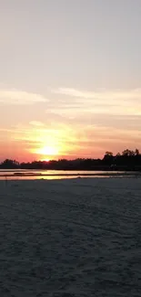 Serene sunset over a tranquil beach, casting warm hues.