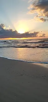 Sunset beach with ocean waves and golden sky on a tranquil evening.