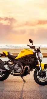 Yellow motorcycle against beach sunset backdrop.