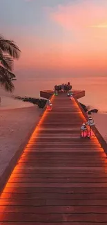 Tropical sunset with a lit beach pier over calm waters.