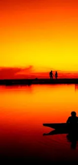 Couple silhouetted against vibrant sunset beach scene.