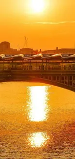 Golden sunset reflecting under a bridge on calm water.