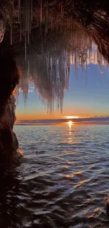 Sunset seen from a sea cave with icicles and ocean view.