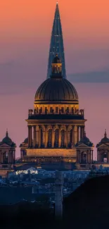 Sunset cityscape with dome silhouette against vibrant sky.