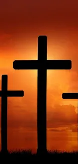 Silhouetted crosses against a vibrant sunset sky, creating a spiritual scene.