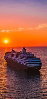 Cruise ship sailing into a vibrant sunset over the ocean.