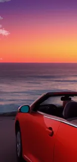 Convertible by the ocean under a vibrant sunset sky.