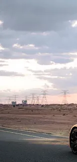 Sports car on open road at sunset with desert landscape.