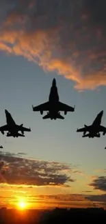 Silhouetted fighter jets flying during a vibrant sunset with colorful clouds.