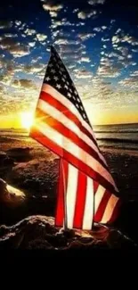 USA flag at sunset on a beach with vibrant sky.