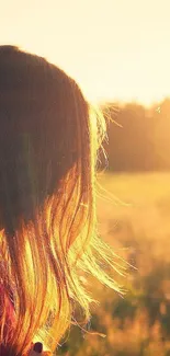 Girl in a golden field at sunset, glowing in natural light.