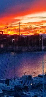 Boats rest at a marina during a vibrant sunset with orange and blue hues in the sky.