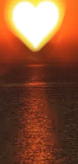 Heart-shaped sunset over calm ocean waters.