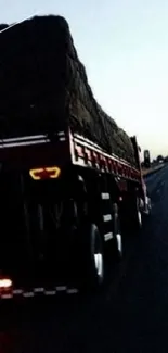 Truck driving on a highway at sunset with scenic view.