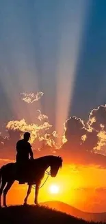 Silhouette of horse rider at sunset with rays in the sky.