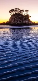 Island beach at sunset with purple and golden sky reflecting in ocean waves.