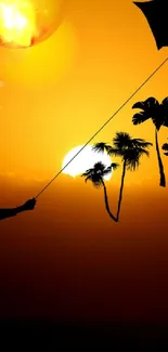 Silhouette of child flying kite at sunset with palm tree backdrop.