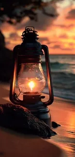 Glowing lantern on beach at sunset with ocean waves.