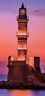 Lighthouse at sunset with vibrant orange and purple sky.