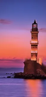 Lighthouse glowing under a sunset sky with vibrant colors.