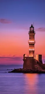 Lighthouse standing against a vibrant sunset over calm ocean waters.