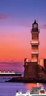 Lighthouse at sunset with ship and vibrant sky.