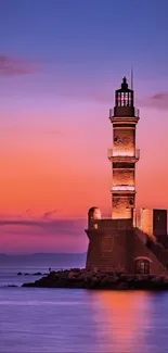 Lighthouse at sunset with vibrant sky hues and calm ocean.