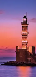 Lighthouse silhouette with vibrant sunset sky.