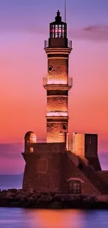 Beautiful lighthouse at sunset over calm sea with vibrant sky colors.