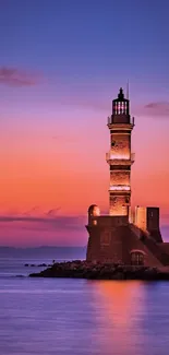 Scenic sunset view with a lighthouse at dusk over the ocean.