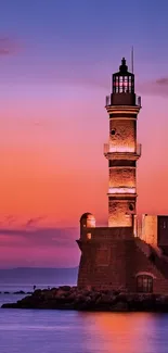 Lighthouse at dusk with stunning sunset sky gradient, perfect mobile wallpaper.