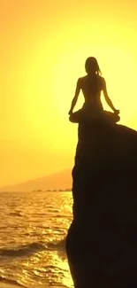 Silhouette in meditation during golden sunset at sea.