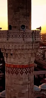 Scenic sunset view of mosque minaret overlooking city skyline.